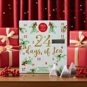 Adventskalender med 24 forskjellige premium teposer i pyramideform, omgitt av julegaver og røde bånd foran rød julegardin.